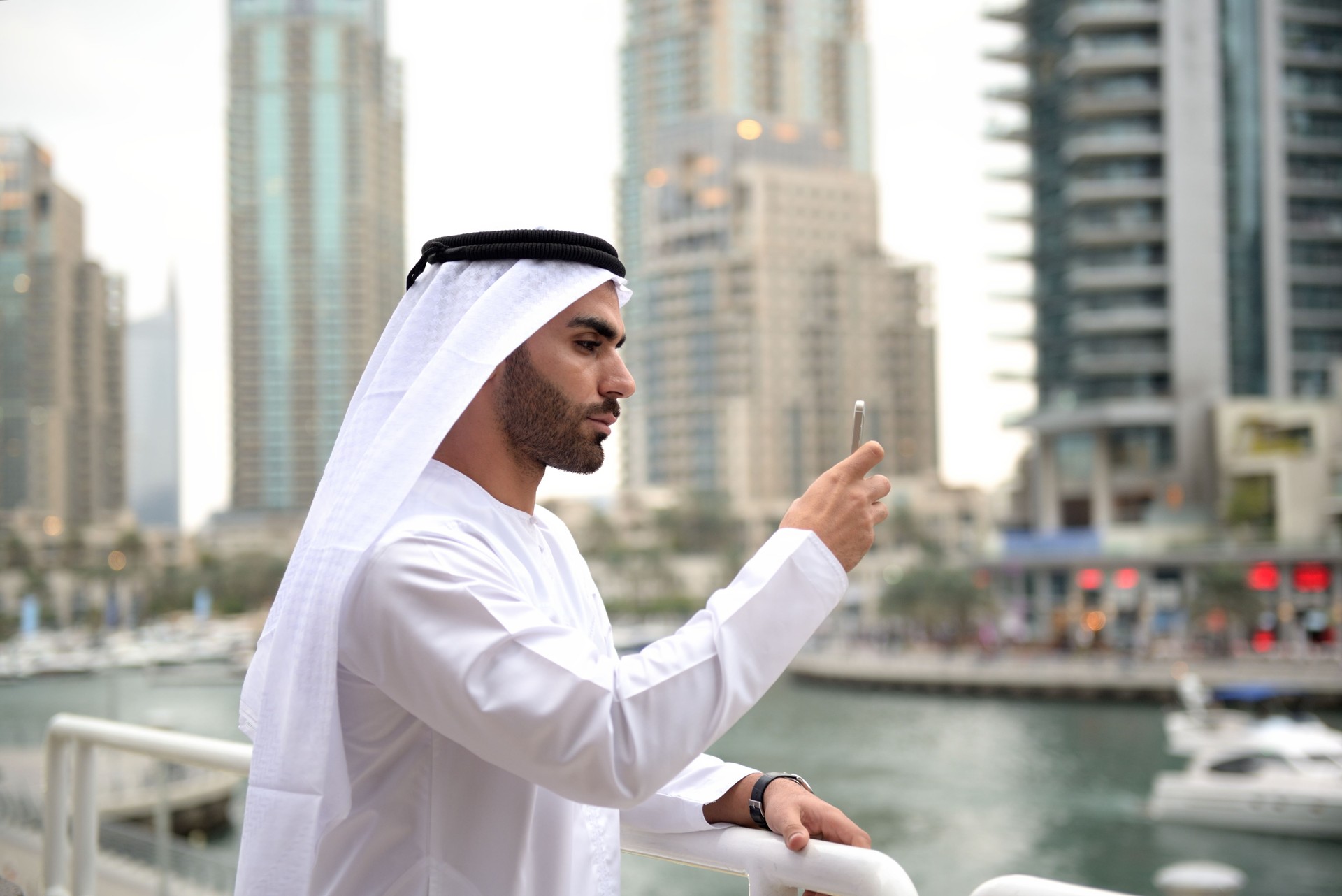 Young Emirati taking photo/selfie with smart phone